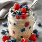 Overnight oats recipe with chia seeds in a glass jar topped with fresh berries